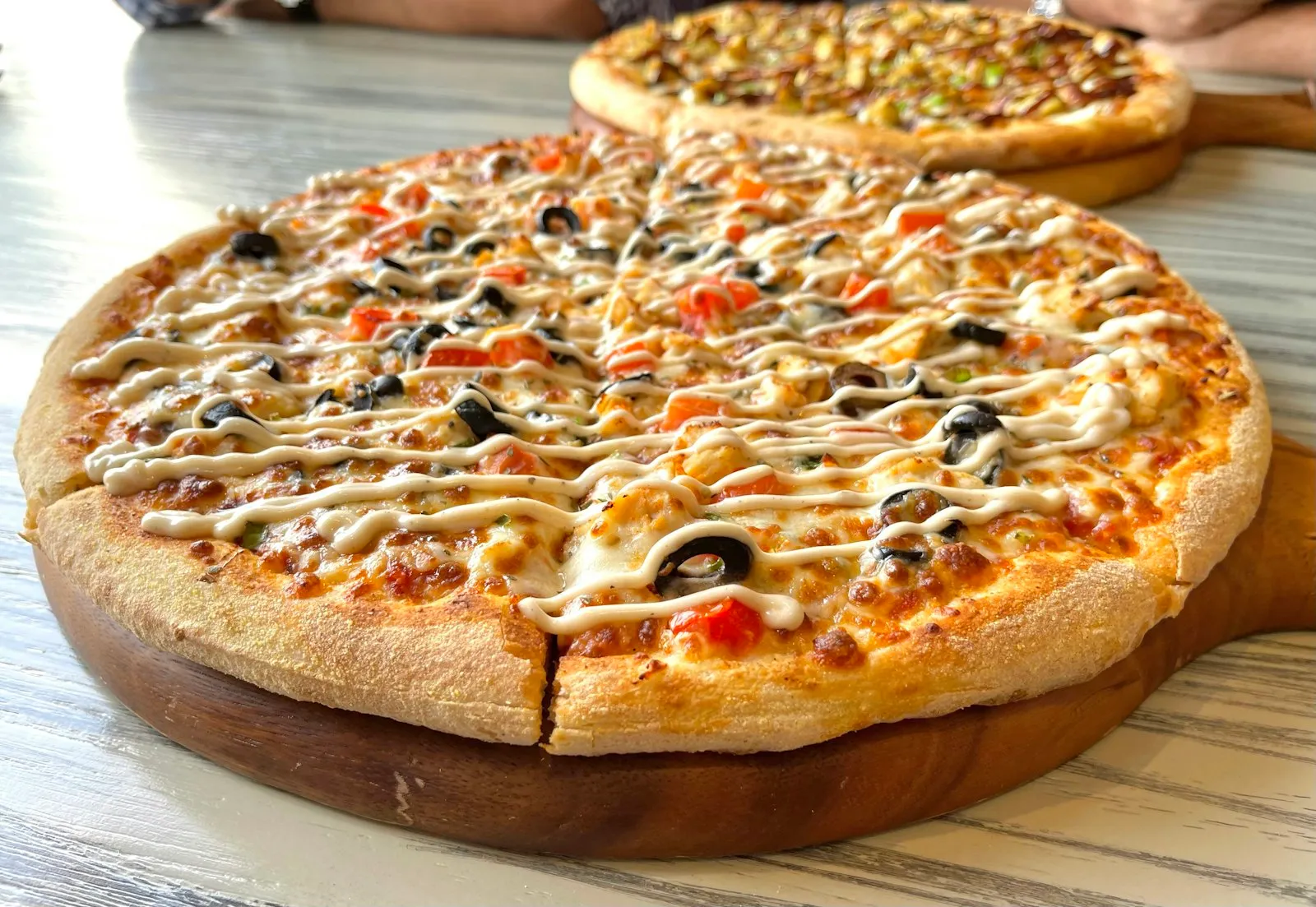 Pizza med hvit saus på trefjøl